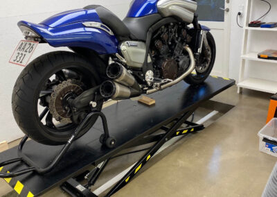 Billedet viser en flot motorcyel på en motorcykellift der kan sænkes ned i gulvet